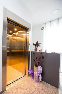 a vase with a purple bow sitting in front of a elevator at Apartma Grže in Postojna