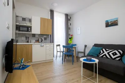 a small living room with a couch and a kitchen at Apartma Grže in Postojna
