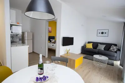 a living room with a white table and a couch at Apartma Grže in Postojna