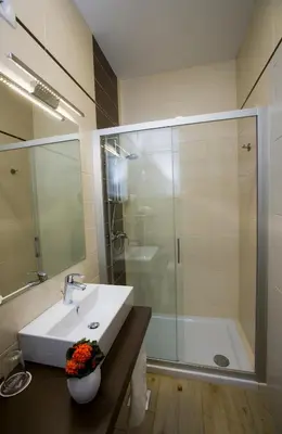 a bathroom with a white sink and a shower at Apartma Grže in Postojna