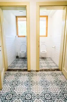 a bathroom with two toilets and a tiled floor at Vila Koman Jezersko in Zgornje Jezersko
