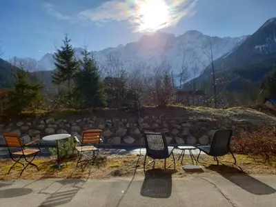 four chairs and a table with a view of a mountain at Vila Koman Jezersko in Zgornje Jezersko