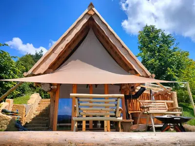 a gazebo with two chairs and an umbrella at Glamping Lake Bloke in Nova Vas