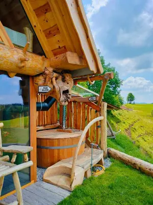 a wooden cabin with a bench and a barrel at Glamping Lake Bloke in Nova Vas