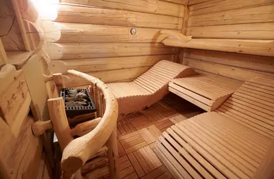an inside view of a wooden sauna with two beds at Glamping Lake Bloke in Nova Vas