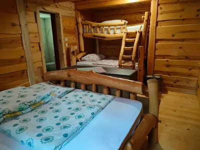 a bedroom with two bunk beds in a log cabin at Glamping Lake Bloke in Nova Vas