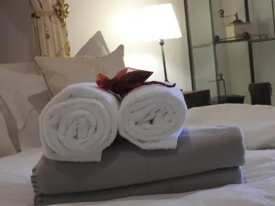 a pile of towels sitting on top of a bed at Karst Stone Cottage in Štanjel