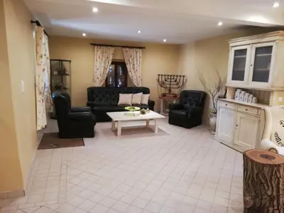 a living room with black chairs and a table at Karst Stone Cottage in Štanjel