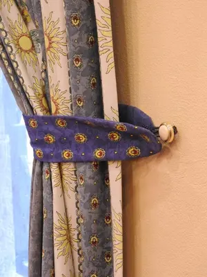 a close up of a blue curtain with flowers on it at Karst Stone Cottage in Štanjel