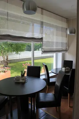 a dining room with two tables and chairs and a window at Yellow Dreamhouse in Postojna