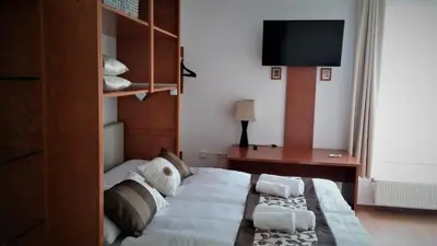 a bedroom with a bed and a desk and a television at Yellow Dreamhouse in Postojna