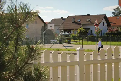 a white picket fence in front of a playground at Yellow Dreamhouse in Postojna