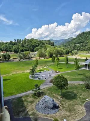 a view of a park with trees and a rock at Hotel Korosica in Šentjanž pri Dravogradu