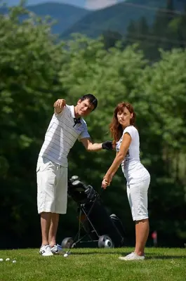a man and a woman playing a game of golf at Hotel Korosica in Šentjanž pri Dravogradu