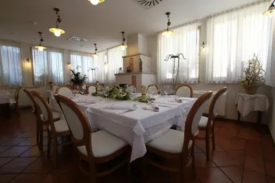 a dining room with a white table and chairs at Boutique Hotel Grahor in Sežana
