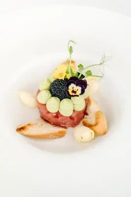 a plate of food with a doughnut with a flower on it at Boutique Hotel Grahor in Sežana