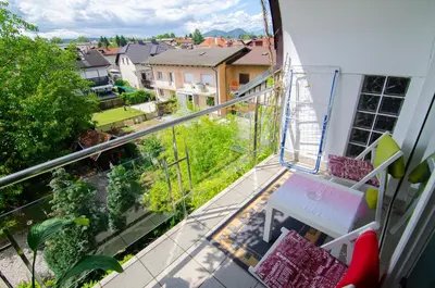 a balcony with a table and a view of a city at Apartments GreenSLO in Ljubljana