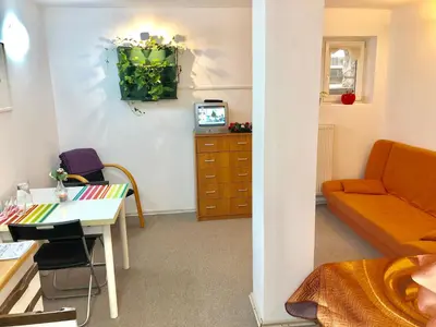 a room with a couch and a table and a desk at Apartments GreenSLO in Ljubljana