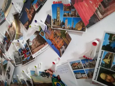a white refrigerator with pictures and magnets on it at Apartments GreenSLO in Ljubljana