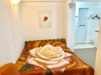 a pink rose sitting on a bed in a room at Apartments GreenSLO in Ljubljana
