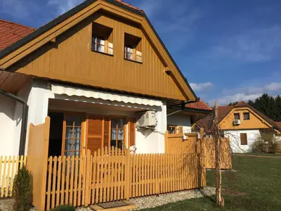 a house with a wooden fence in front of it at Apartma Jelenček in Moravske Toplice