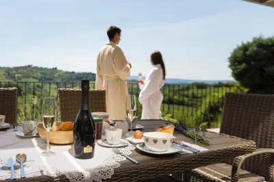 a table with a bottle of wine and a man and a woman at Villa EVA in Dobrovo