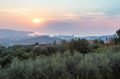 a view of the sun setting over a city at Villa EMI in Zgornje Škofije