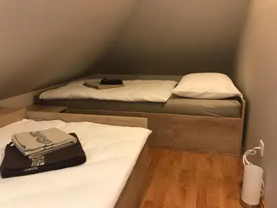 two beds in a small room with white sheets at Vila Lesce with heated outdoor pool in Lesce