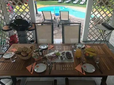 a table with food on it on a deck with a pool at Vila Lesce with heated outdoor pool in Lesce