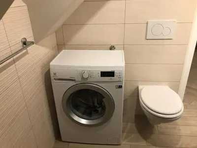 a small bathroom with a washing machine and a toilet at Vila Lesce with heated outdoor pool in Lesce