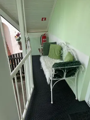 a room with a white bench with green pillows at Vila Lesce with heated outdoor pool in Lesce