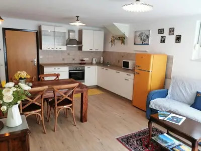 a kitchen and living room with a table and a couch at Barn House MM in Bled