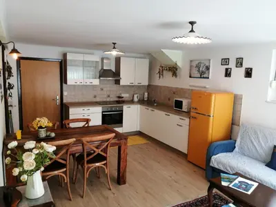 a kitchen and living room with a table and a couch at Barn House MM in Bled