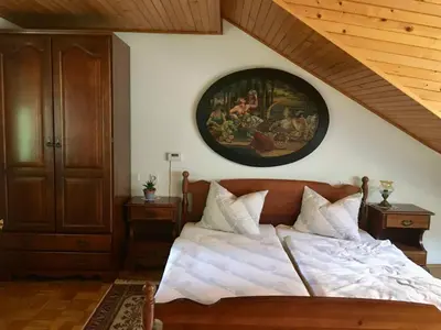 a bedroom with a bed with a painting on the wall at Guest House Atelšek in Rečica ob Savinji