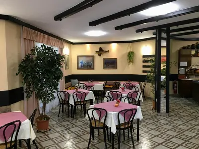 a restaurant with pink tables and chairs in a room at Guest House Atelšek in Rečica ob Savinji