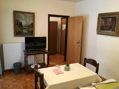 a living room with a table and a television at Guest House Atelšek in Rečica ob Savinji