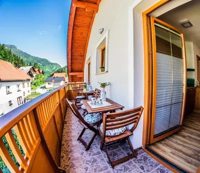 a balcony with a table and chairs on it at Apartments BBI in Luče