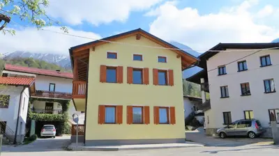 a building with red and blue windows on a street at Holiday House Kanalec in Drežnica