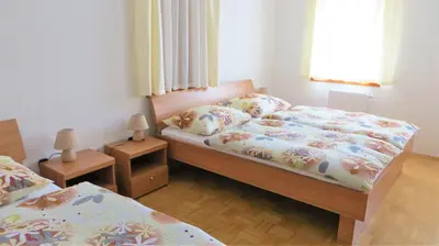 a small bedroom with two beds and two lamps at Holiday House Kanalec in Drežnica
