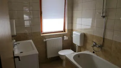 a bathroom with a toilet and a sink and a tub at Holiday House Kanalec in Drežnica