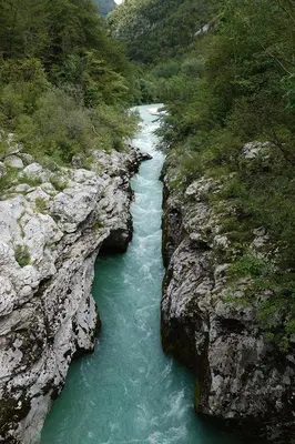 a river flowing through a rocky mountain with green water at Apartma pod Rožem in Soča
