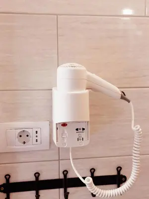 a white phone is plugged into a socket at Apartment Ravnik in Bled