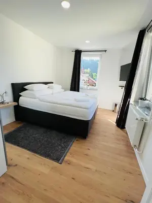 a bedroom with a bed and a large window at Guesthouse Avsenik in Begunje na Gorenjskem