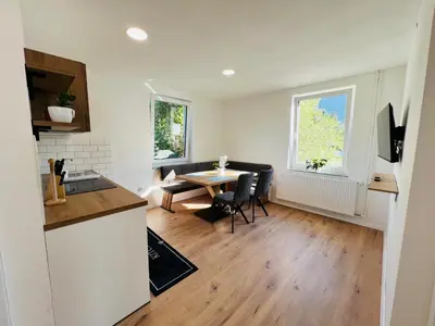 a kitchen and living room with a table and a dining room at Guesthouse Avsenik in Begunje na Gorenjskem