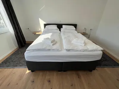 a large bed with white sheets and pillows on it at Guesthouse Avsenik in Begunje na Gorenjskem