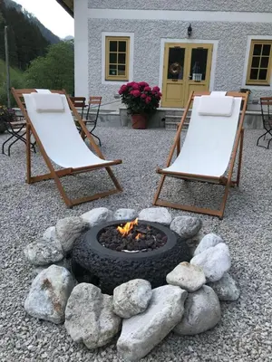 two chairs and a fire pit in a yard at Boutique rooms Pri Rogovilcu in Solčava