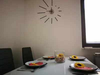 a table with plates of food and a clock on the wall at House Čeh in Črni Kal