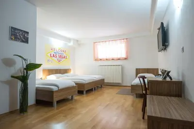 a hospital room with three beds and a table at Guest House Mlada lipa in Maribor