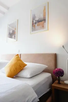 a bedroom with a bed with a yellow pillow at Guest House Mlada lipa in Maribor