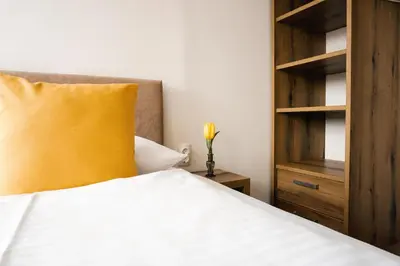 a bed with a yellow pillow and a wooden cabinet at Guest House Mlada lipa in Maribor